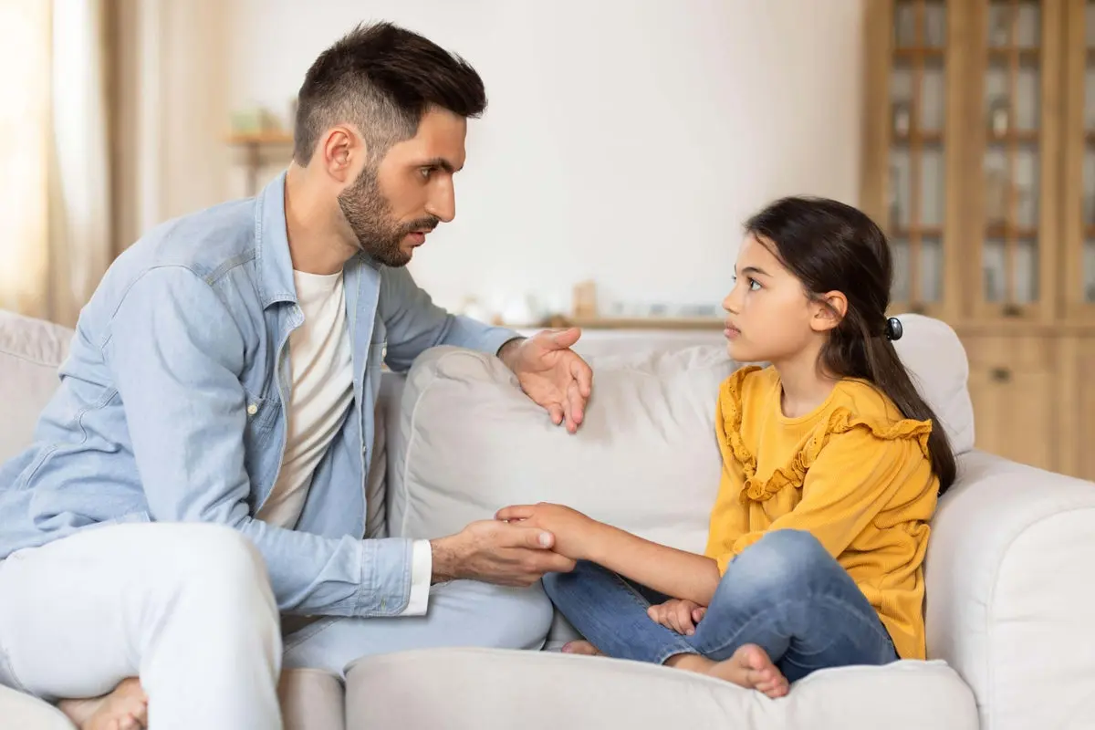 کودکی که در آغوش والدینش است و احساس امنیت می‌کند