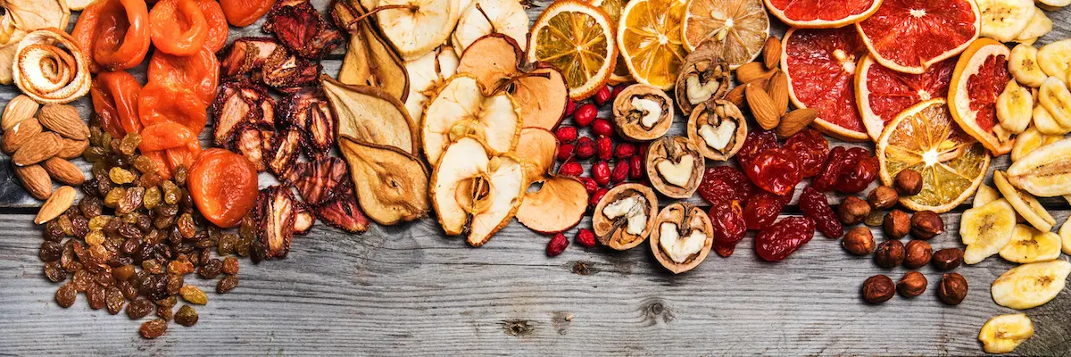 چندین نوع میوه خشک در یک ظرف شیشه‌ای