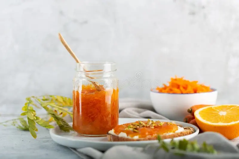 مربای هویج در کنار آب پرتقال در زمینه خاکستری