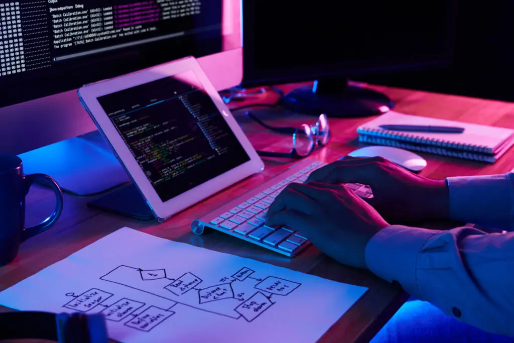 برنامه‌نویس در حال کار روی کدهایش در میز کار خود