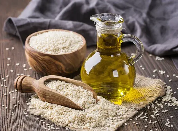 دانه و روغن کنجد در ظرف شیشه‌ای