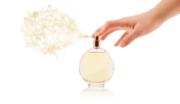 زنی که عطر را روی دست خود اسپری می‌کند