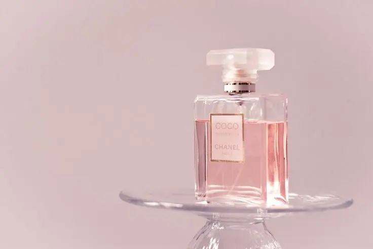 بوتیک عطر با مجموعه‌ای از عطرهای گرم زنانه در قفسه