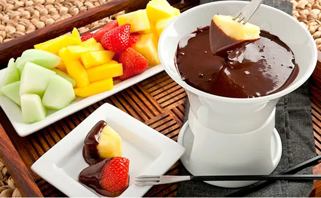 فوندو خوری با دستگاه گرمایشی و کاسه‌های جانبی برای مواد غذایی