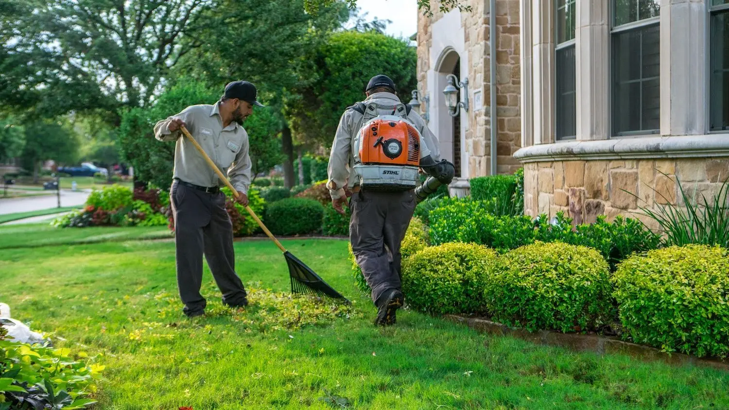 یک تیم باغبانی در حال انجام عملیات نگهداری در یک فضای سبز بزرگ
