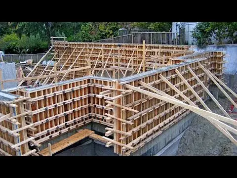 کارگر قالببندی در حال بررسی دقت ابعاد یک قالب بتنی