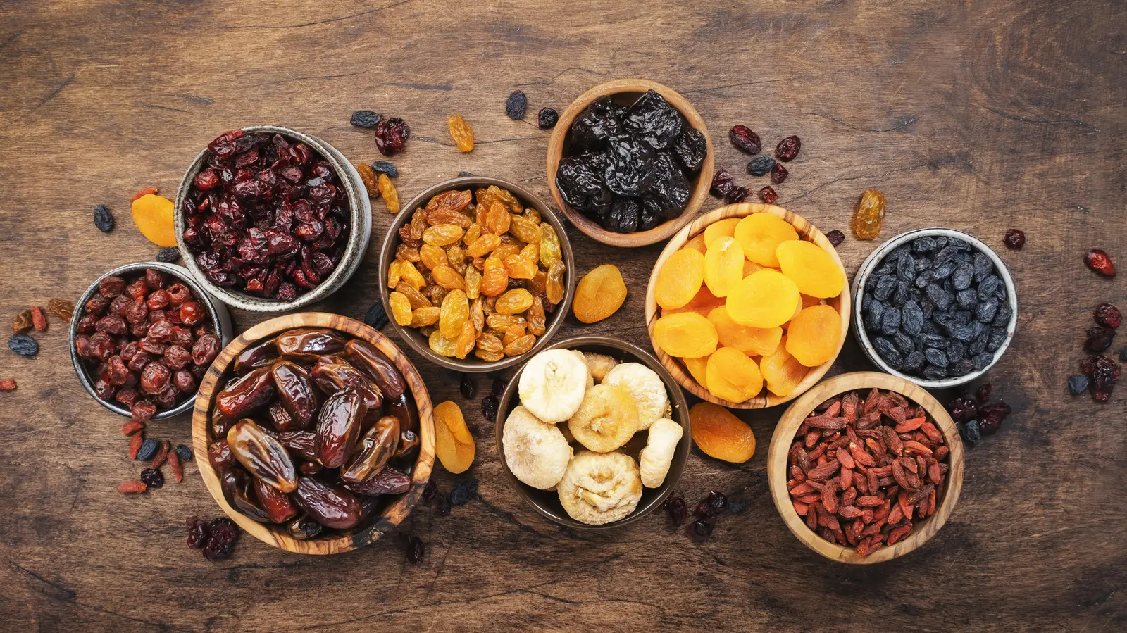 چندین نوع میوه خشک در یک ظرف شیشه‌ای با یک قاشق چایخوری