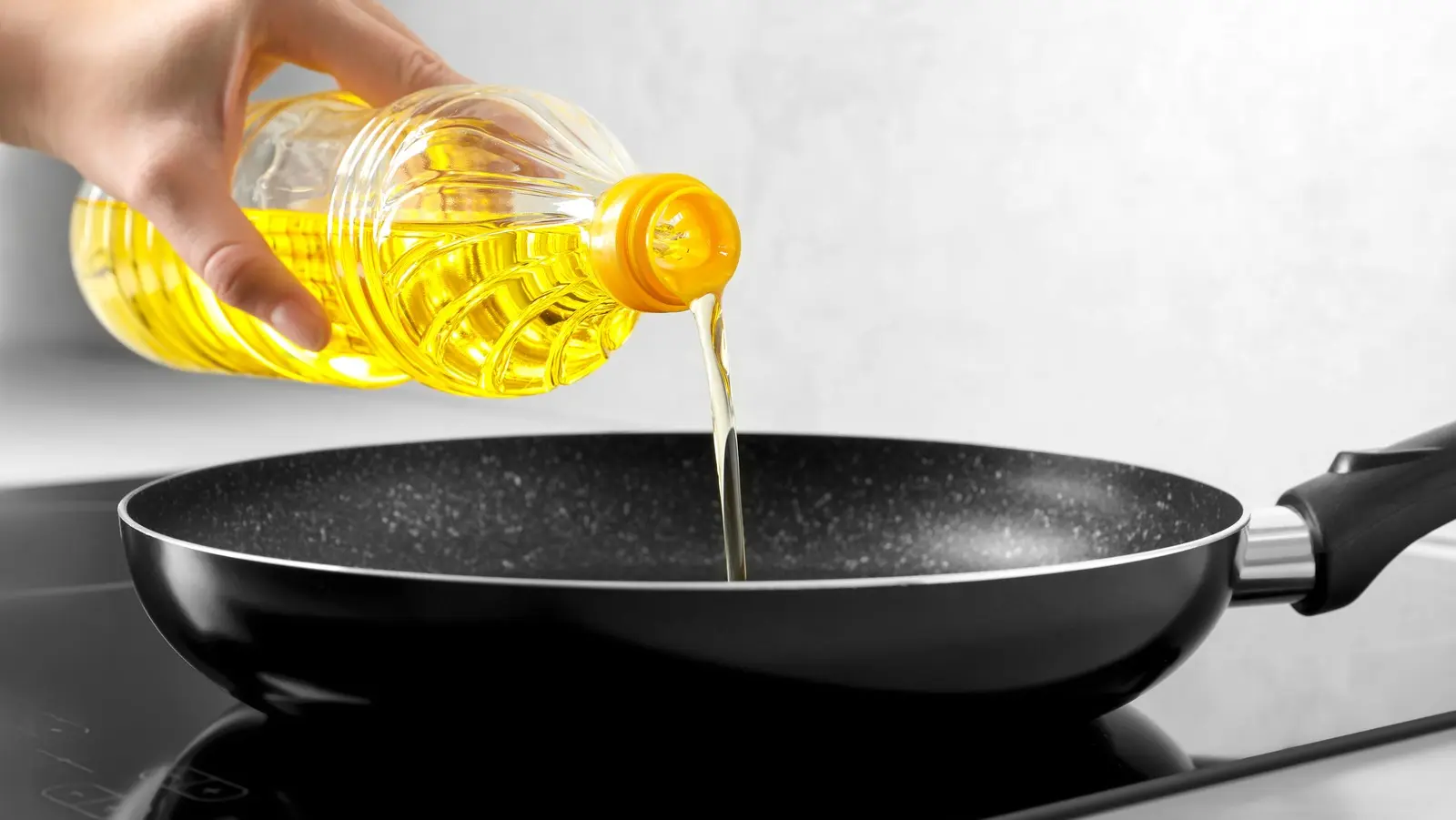 چندین نوع روغن در بطری‌های مختلف در کنار غذاهای پخته شده