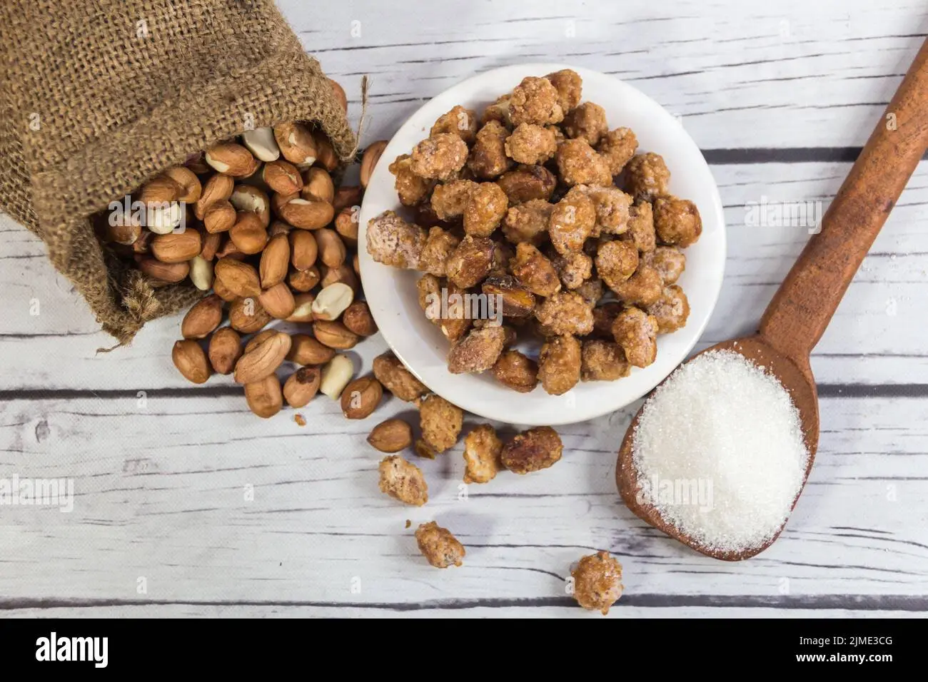 آجیل شور و مواد اولیه تهیه آن در یک ظرف شیشه‌ای