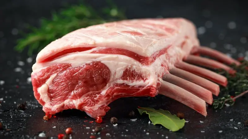 گوشت گوسفندی تازه و سالم با چربی طبیعی و علف‌های تازه
