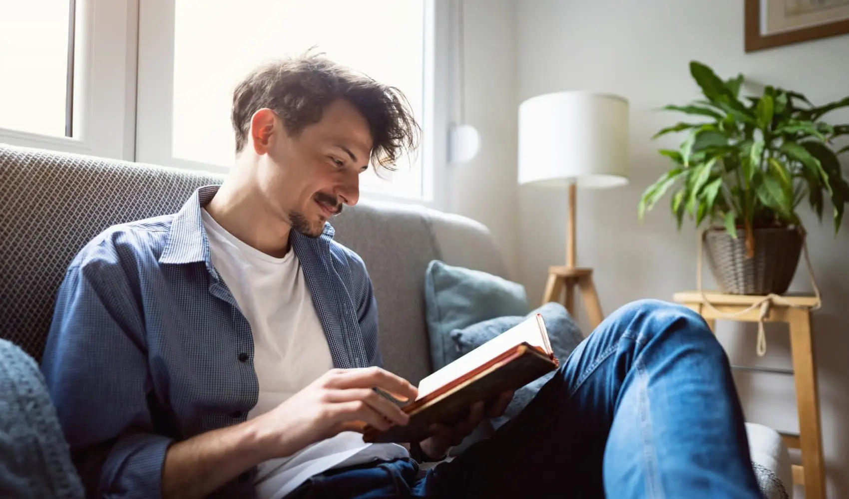 والدین و کودک در حال خواندن کتاب در کنار یکدیگر