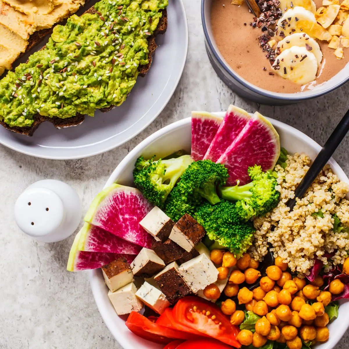 یک میز غذا با انواع سبزیجات تازه، میوه‌ها و غذاهای وگان