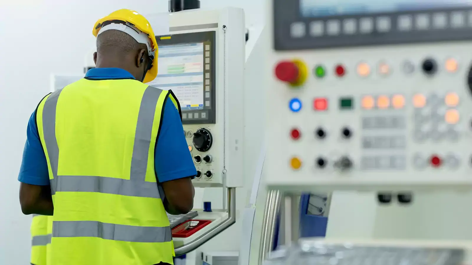اپراتور CNC در حال بررسی و تنظیم ماشین‌آلات با دقت