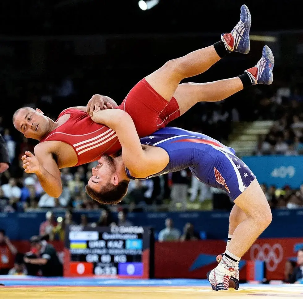 دو کشتی‌گیر در حال مسابقه در سبک کشتی آزاد با استفاده از تکنیک‌های مختلف