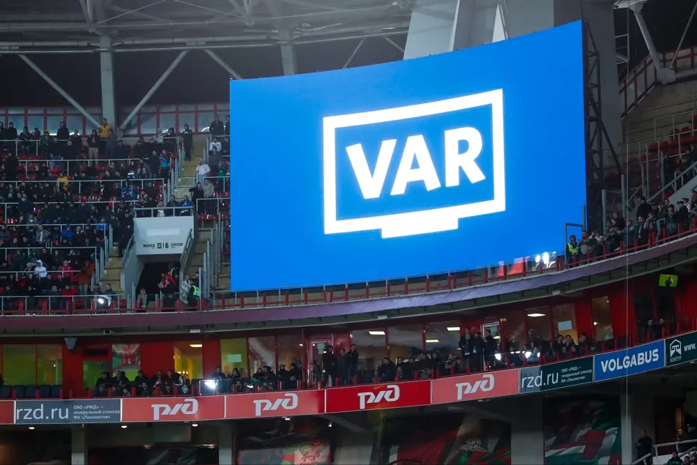 داوران فوتبال در حال استفاده از سیستم VAR برای بررسی یک تصمیم