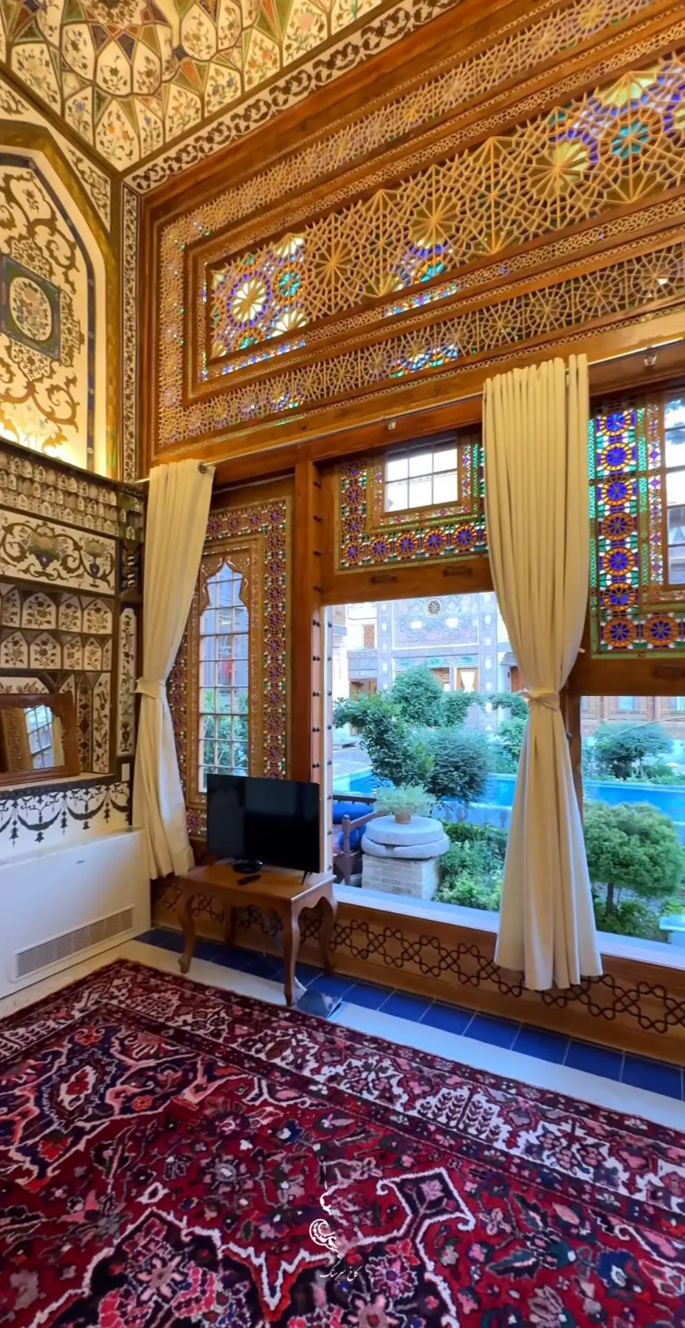 مبلمان چوبی با نقش‌های منبت‌کاری و فرش دست‌بافت