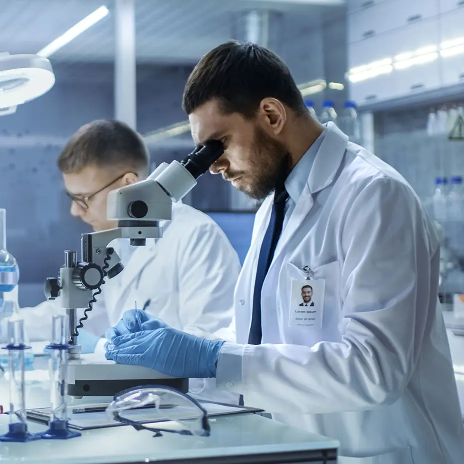 پژوهشگر با استفاده از میکروسکوپ در آزمایشگاه